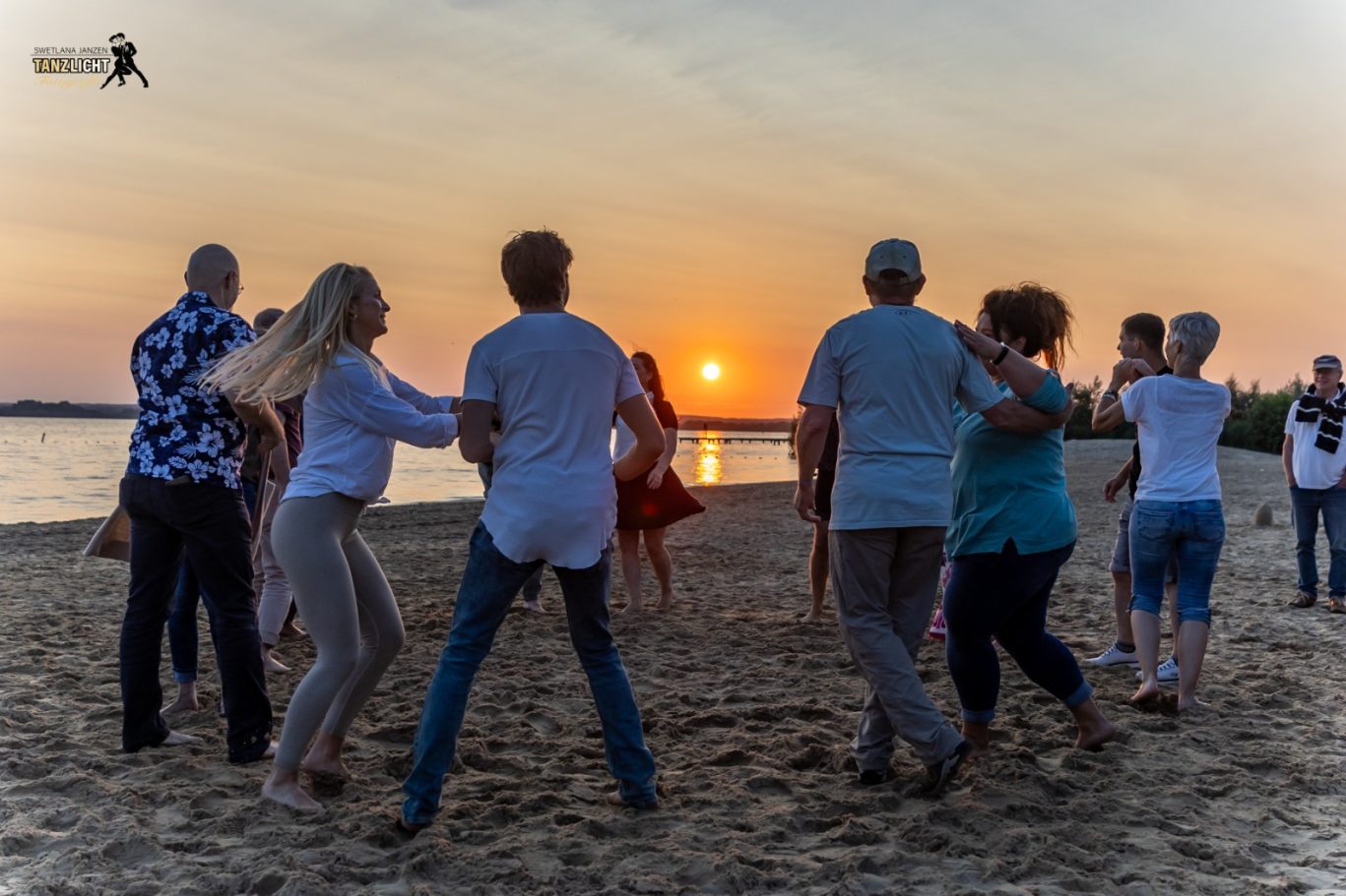 Menschen tanzen Salsa am Strand vor der Sonnenbar zum Sonnenuntergang